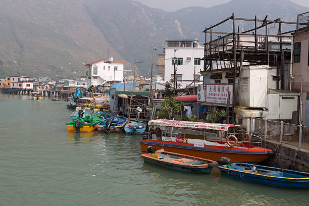 Hong Kong, China - February 12, 2012: People at Tai O Fishing Town, Lantau Island, Hong Kong. The houses at Tai O are built on river stilts and its lanes are filled with shops selling dried seafood. It is a tourist attraction in Hong Kong.
